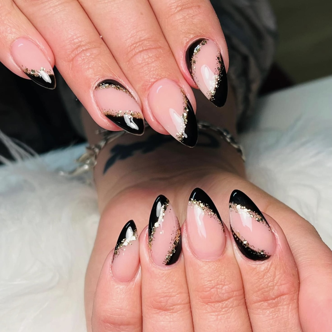 Amandelnagels met een zwarte french en bladgoud