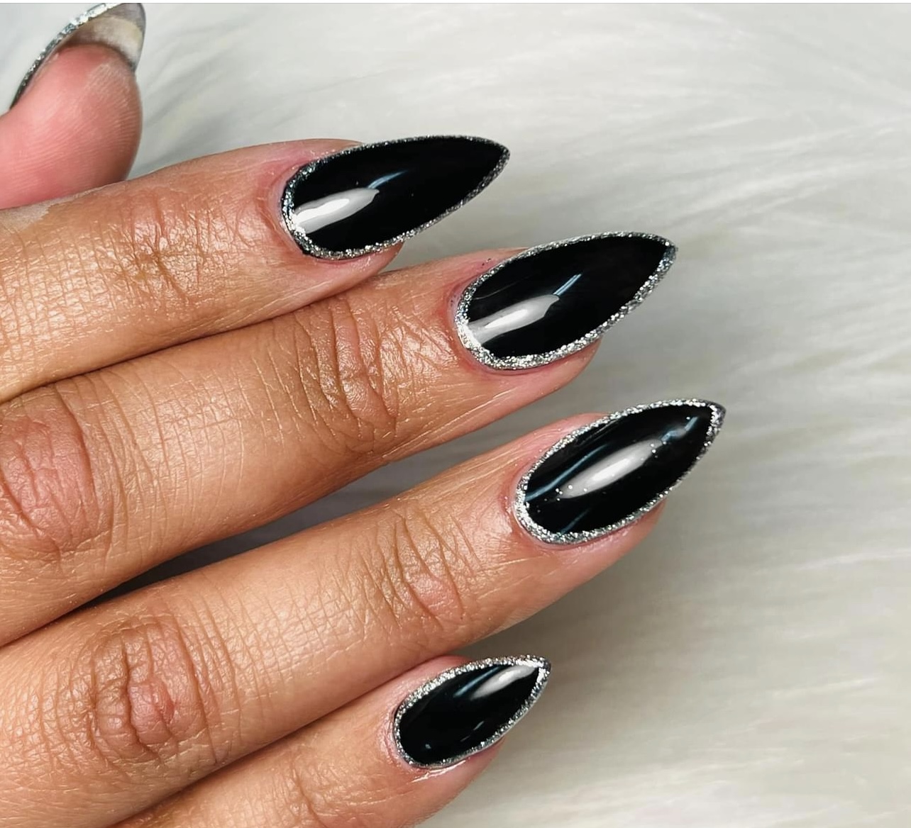 Lange puntige zwarte nagels met een zilveren rand