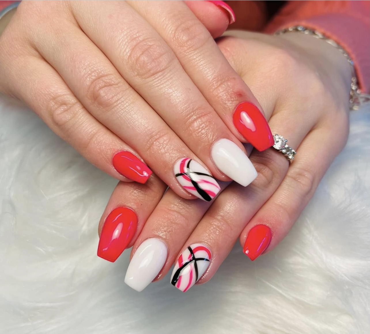 Rode en witte nagels met lijntjes op twee nagels